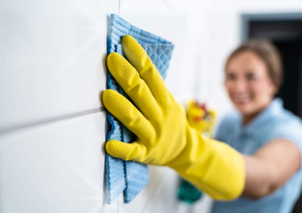 Homeowner cleaning basement walls to remove musty odors