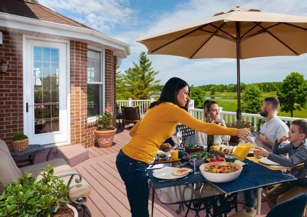 Family enjoying outdoor time under a large patio umbrella in a backyard.