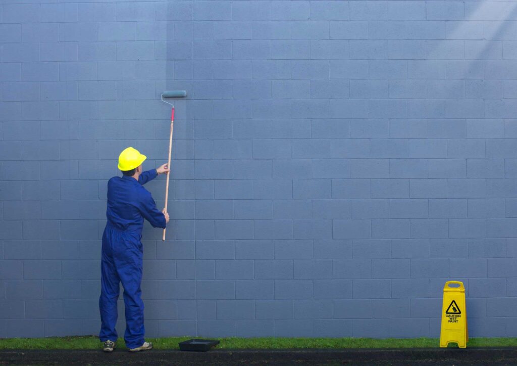 Applying exterior paint to house siding using roller and brush with proper technique