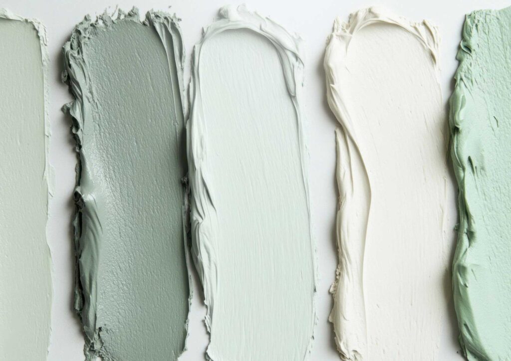 Exterior paint color samples tested on different sides of a house in sun and shade
