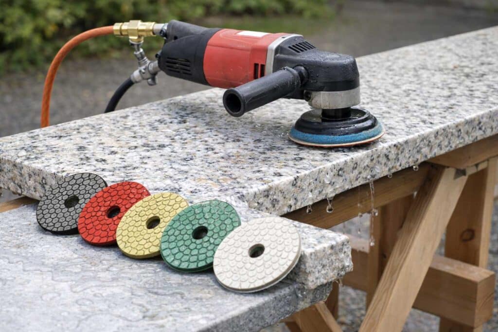 Fabricator using wet polisher to shape granite countertop edge