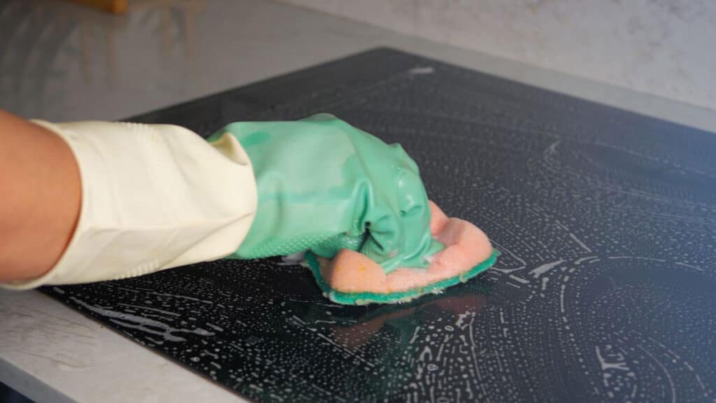 Non scratch scrubber cleaning burnt grease from glass top stove