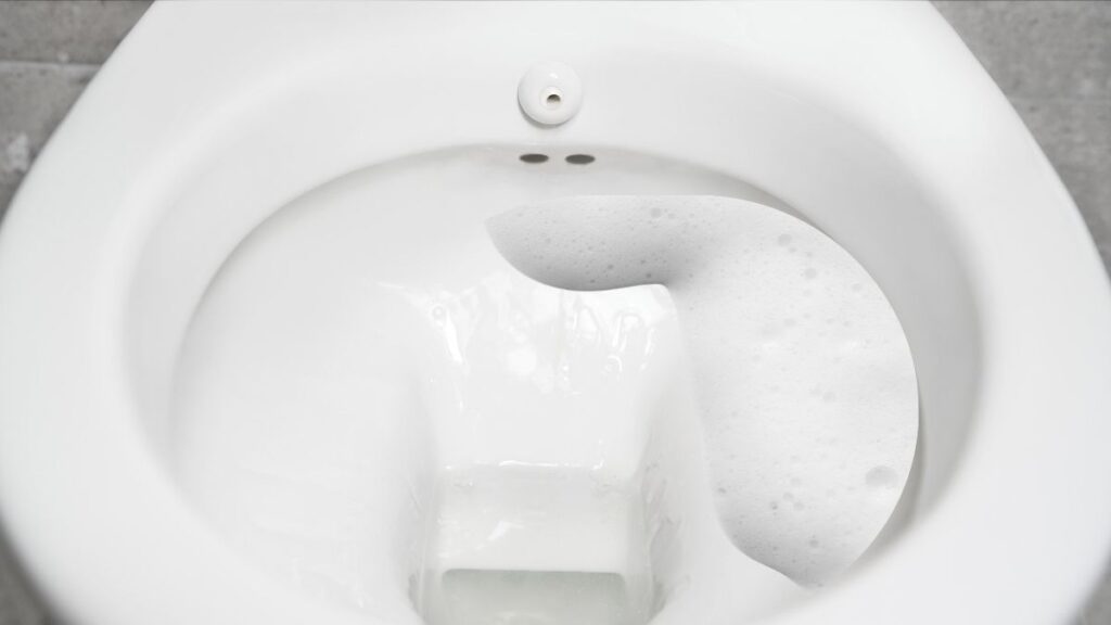 baking soda and vinegar bubbling in toilet bowl to loosen stains