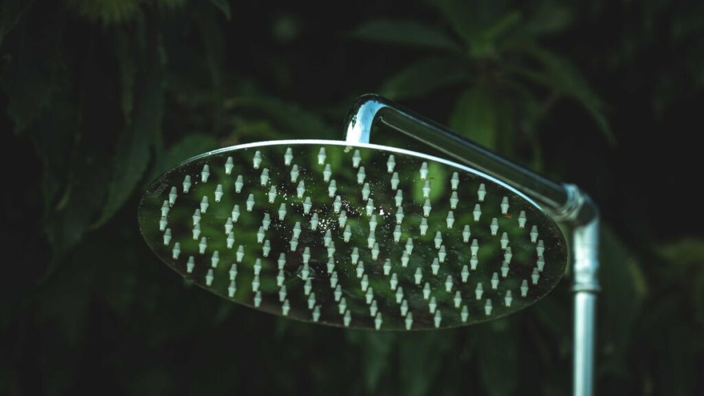 shower head with visible mineral buildup on spray nozzles before cleaning