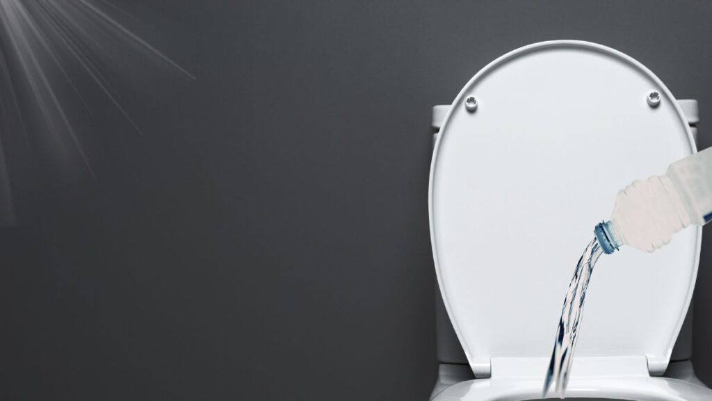 Cleaning a toilet with vinegar and baking soda in a residential bathroom