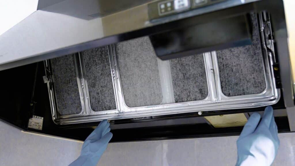 Grease buildup on metal range hood filter requiring cleaning