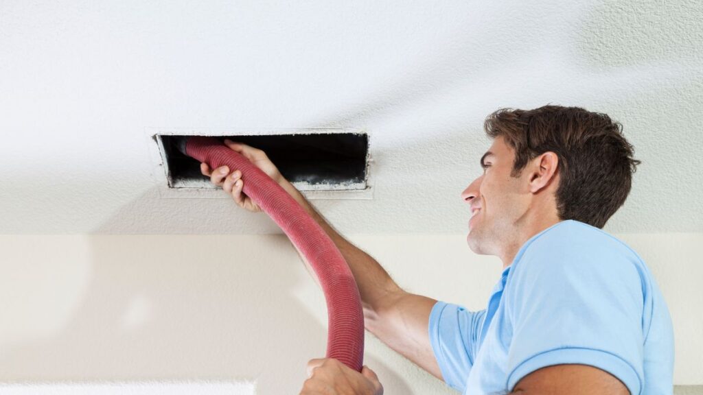 inspecting bathroom exhaust fan duct opening for debris