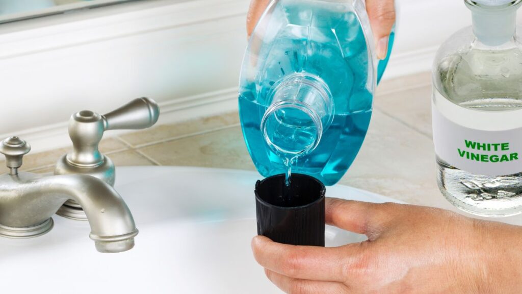 Mixing white vinegar and Dawn dish soap in spray bottle for shower cleaning