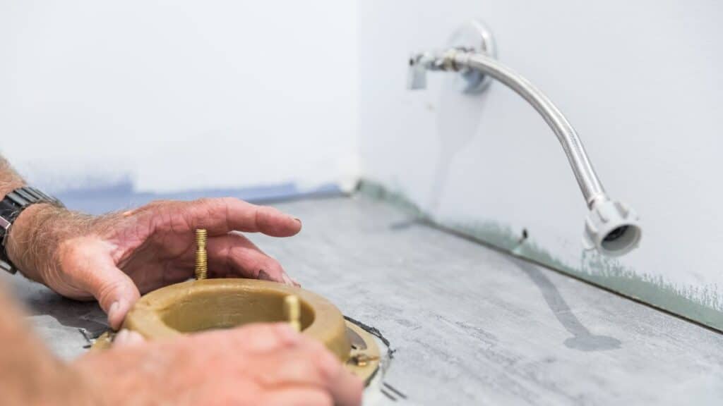 Toilet removed showing exposed flange and subfloor inspection area