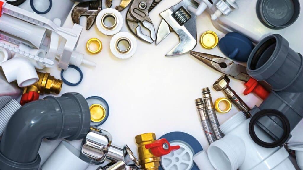 basic tools and materials for toilet repair including wrench and cleaner