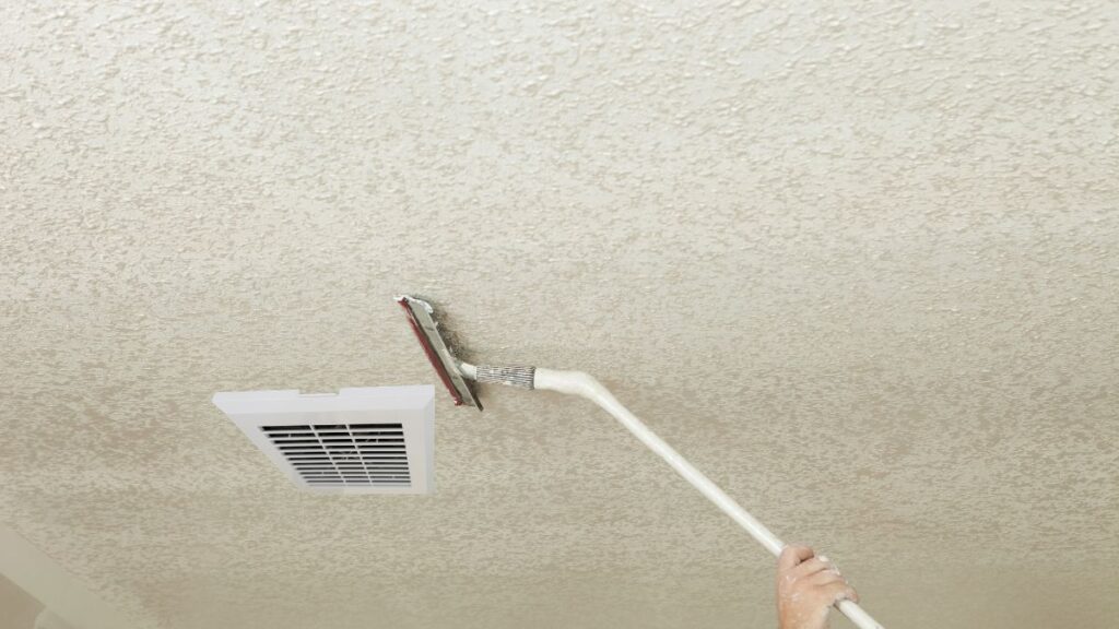 vacuuming dust from bathroom exhaust fan blades and housing