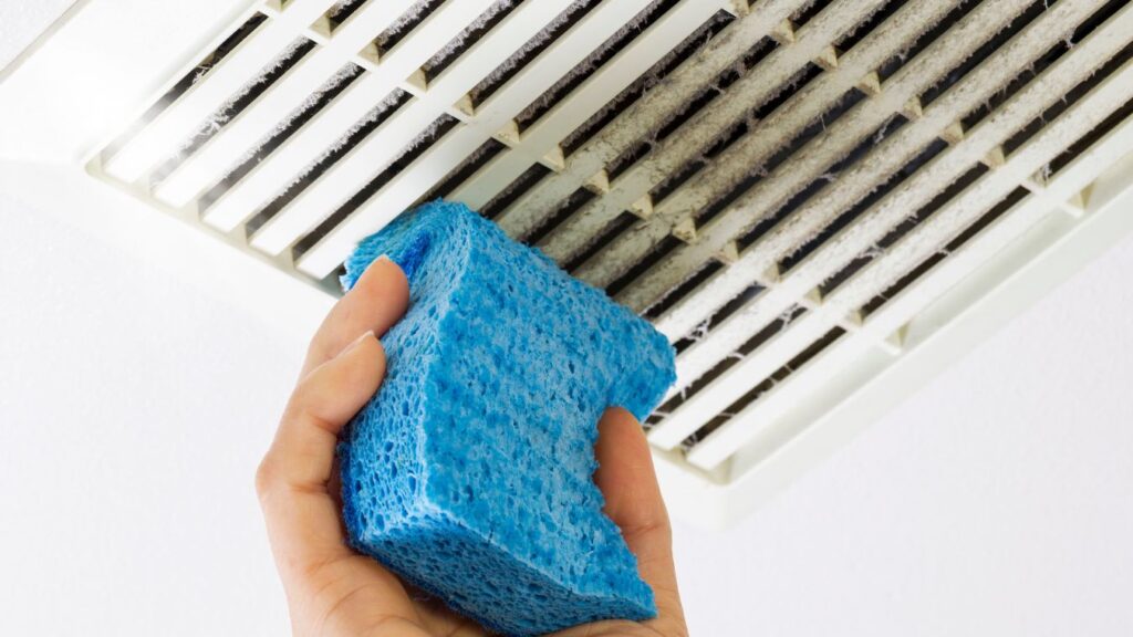 vacuum cleaning dust from inside bathroom exhaust fan housing